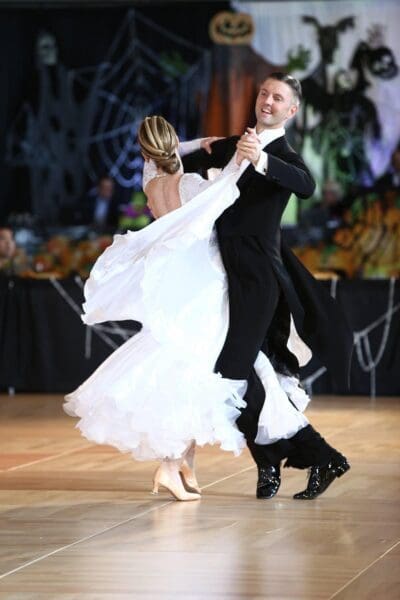 A man and woman dancing in formal wear.