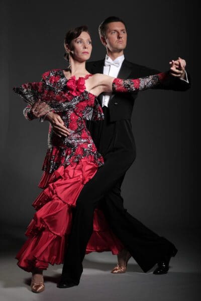 A man and woman dancing in formal wear.