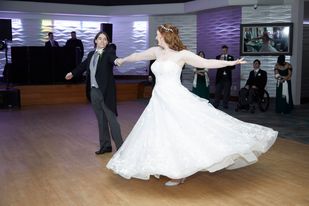 A man and woman in wedding dress dancing.