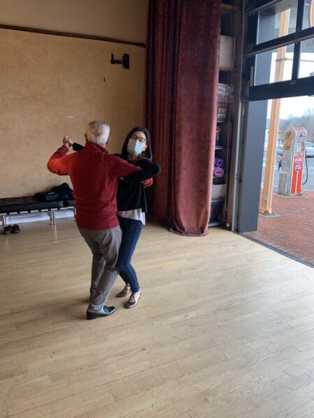 A man and woman dancing in an empty room.