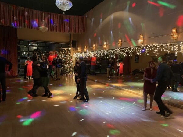 A group of people dancing in a room with lights.