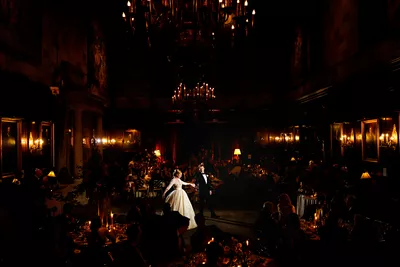 A couple is dancing in the dark at their wedding.