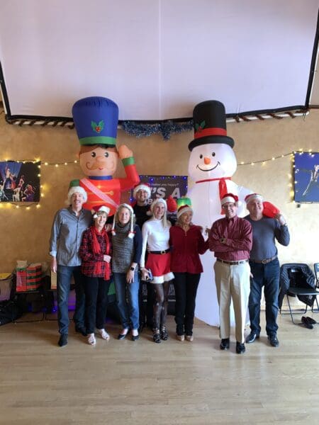 A group of people standing in front of giant inflatable snowman.