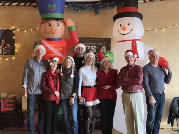 A group of people standing in front of inflatable christmas decorations.