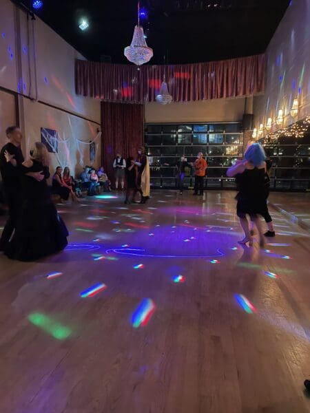 A group of people in a room with lights on the floor.