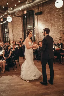 A bride and groom are dancing at their wedding.