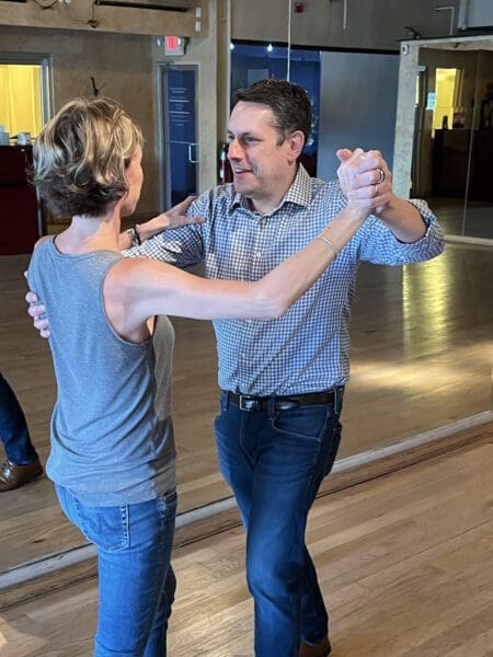 A man and woman dancing in the middle of a room.