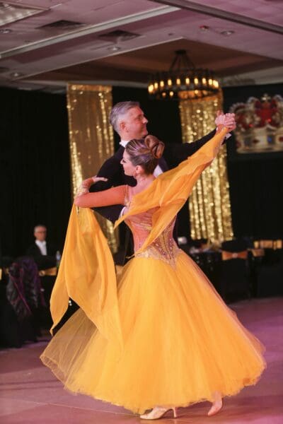 A man and woman dancing in a ballroom.